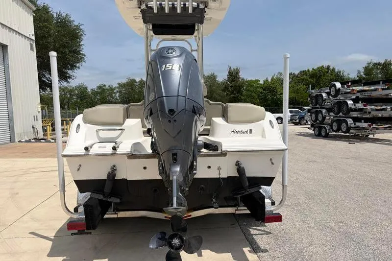 Slide: The Image of 2024 Key West 203 FS boat with Yamaha 150 engine, parked outdoors. - 13