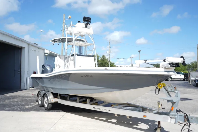 The Image of 2021 Ranger 2600 Bay boat on trailer, parked outdoors under a clear blue sky. - 0