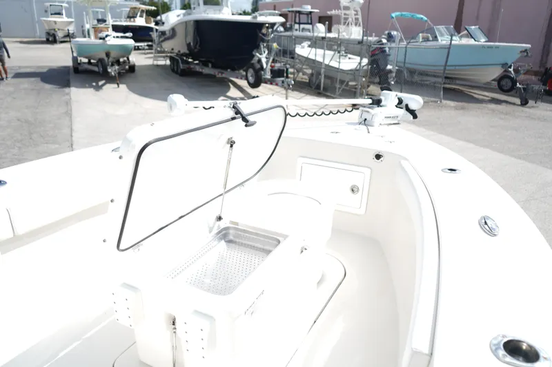 Slide: The Image of 2021 Ranger 2600 Bay boat with open storage compartment, docked among other boats. - 14