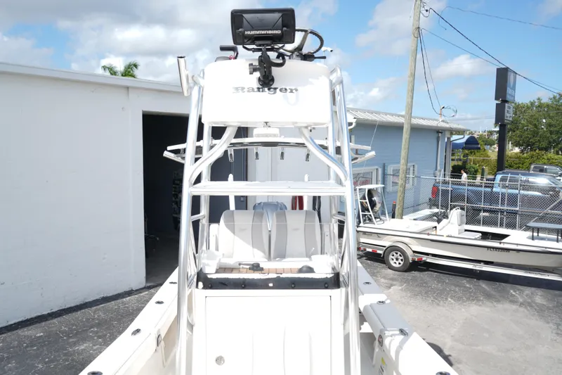 Slide: The Image of 2021 Ranger 2600 Bay boat with tower and electronics, parked outdoors under a blue sky. - 15