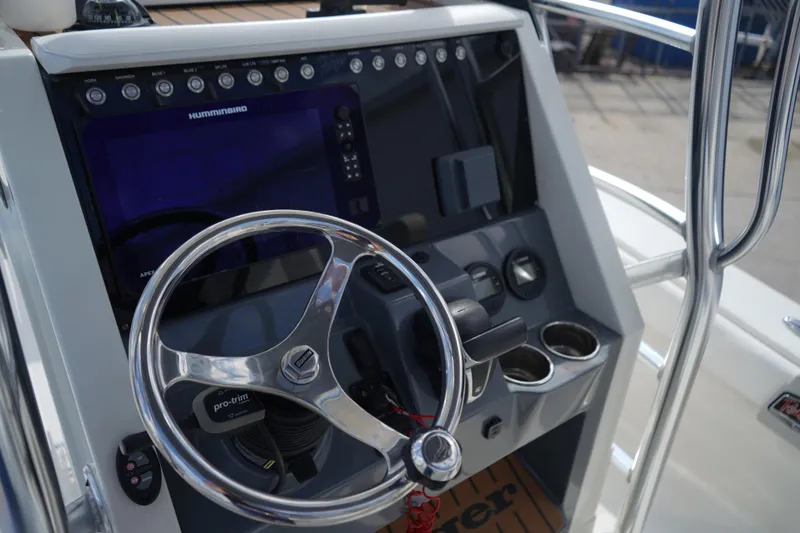 Slide: The Image of 2021 Ranger 2600 Bay boat helm with steering wheel and navigation controls. - 9