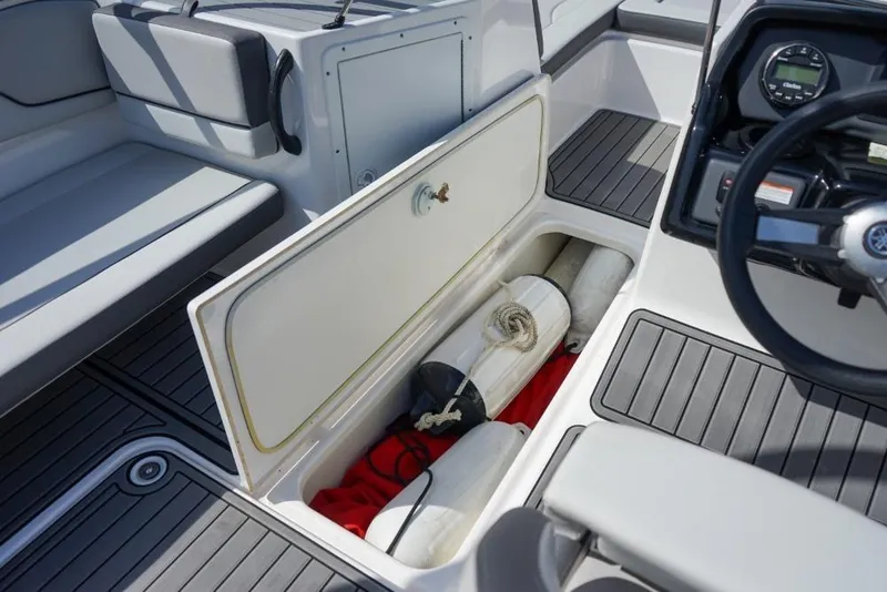 Slide: The Image of 2019 Yamaha Boats AR190 interior storage compartment with safety equipment and accessories. - 14