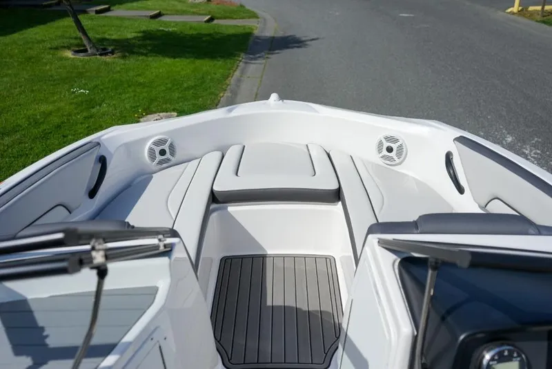 Slide: The Image of 2019 Yamaha Boats AR190 interior with seating and speakers, docked near a grassy area. - 16