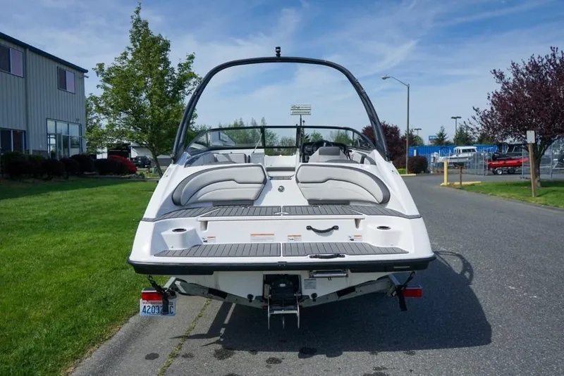 Slide: The Image of 2019 Yamaha Boats AR190, rear view, parked on a street with green grass and trees. - 4