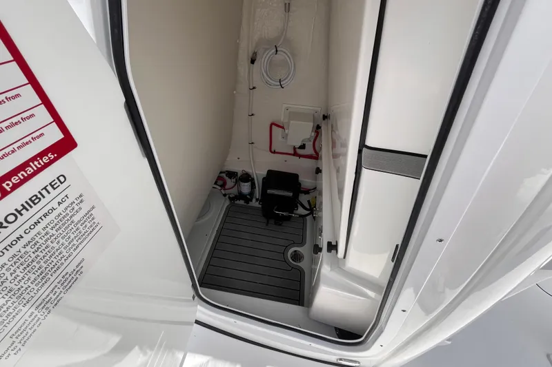 Slide: The Image of Interior view of 2026 Tidewater 2500 Carolina Bay boat compartment with equipment and warning label. - 12