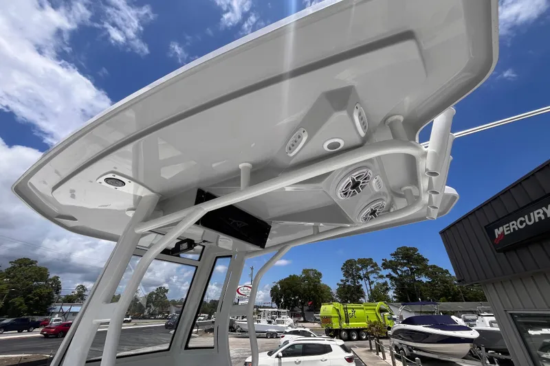 Slide: The Image of Tidewater 2500 Carolina Bay 2026 boat T-top with speakers, under a clear blue sky. - 14