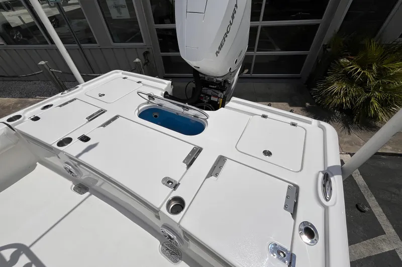 Slide: The Image of 2026 Tidewater 2500 Carolina Bay boat deck with Mercury engine, featuring storage compartments. - 15