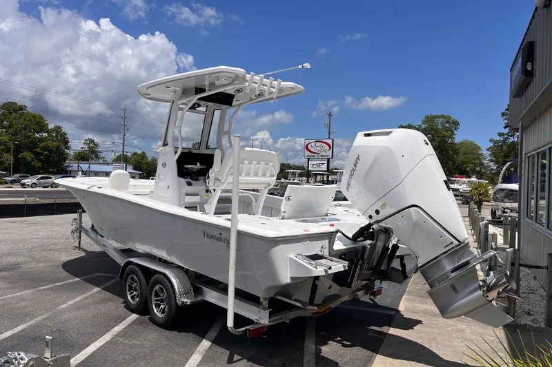 Slide: The Image of 2026 Tidewater 2500 Carolina Bay boat with Mercury engine on trailer, parked outdoors. - 2
