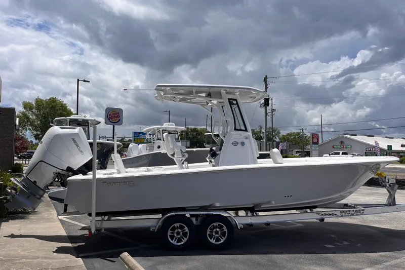 Slide: The Image of 2026 Tidewater 2500 Carolina Bay boat on trailer, parked outdoors under cloudy sky. - 3