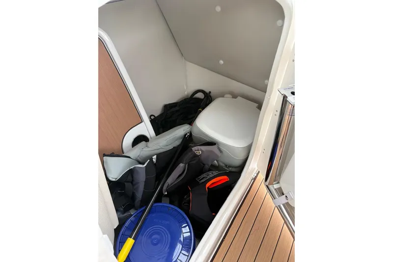 Slide: The Image of 2023 Yamaha Boats 252SD interior storage with toilet and boating gear. - 11