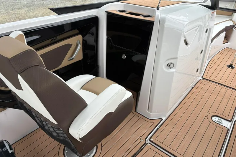 Slide: The Image of 2023 Yamaha Boats 252SD interior with brown and white seating, wood-style flooring. - 12