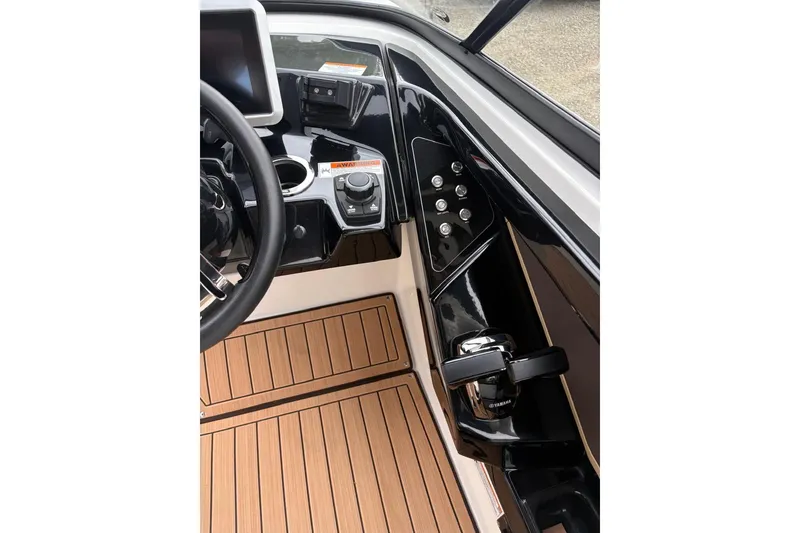 Slide: The Image of 2023 Yamaha Boats 252SD helm with sleek controls and wood-style flooring. - 13