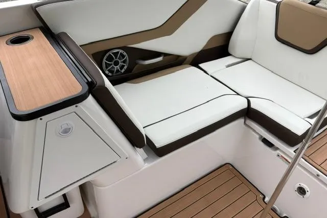 Slide: The Image of 2023 Yamaha Boats 252SD interior with white and brown seating, speaker, and wood accents. - 8