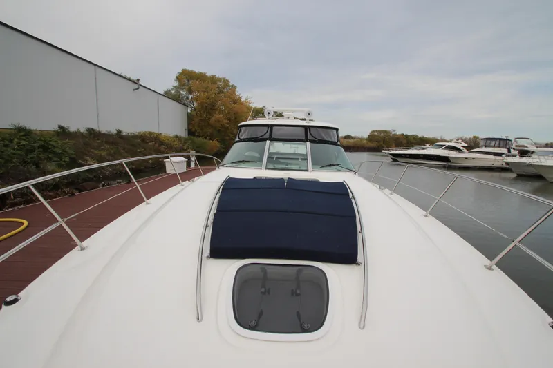 Slide: The Image of 2007 Sea Ray 44 Sundancer yacht docked, showcasing sleek design and spacious deck. - 11