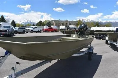 Slide: The Image of 2024 Lowe L1648M Aura Jon boat on trailer, parked outdoors under a blue sky. - 2