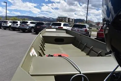 Slide: The Image of 2024 Lowe L1648M Aura Jon boat in parking lot, surrounded by cars under a cloudy sky. - 6