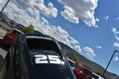 Slide: The Image of Outboard motor with "25" label on a 2024 Lowe L1648M Aura Jon boat under a blue sky. - 8