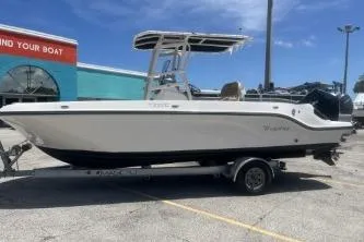 Slide: The Image of 2023 Trophy T22 boat on trailer, parked outdoors near a boat dealership. - 5