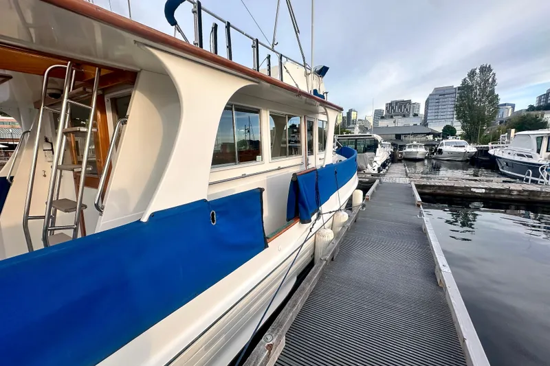 Slide: The Image of 1991 Grand Banks 36 Europa yacht docked at marina with cityscape background. - 4