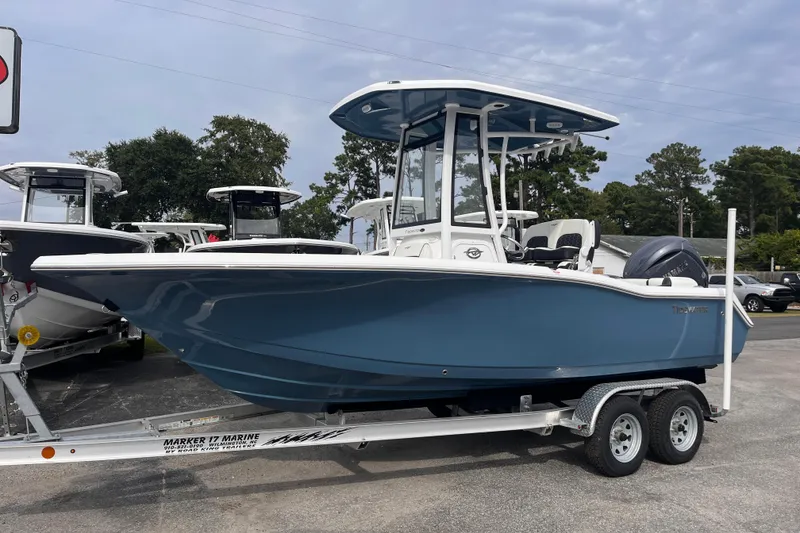 Slide: The Image of 2026 Tidewater 210 LXF boat on trailer, blue hull, parked outdoors. - 1