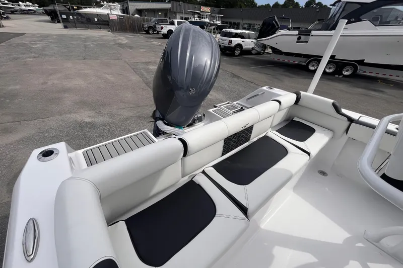 Slide: The Image of 2026 Tidewater 210 LXF boat interior with seating and outboard motor in a marina setting. - 5