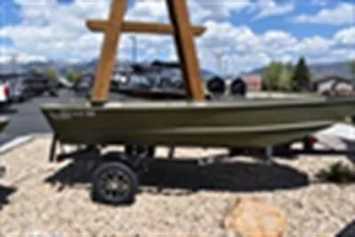 The Image of 2024 Lowe L1448M Jon boat on trailer under clear blue sky. - 0