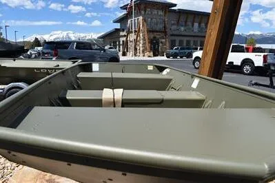 Slide: The Image of 2024 Lowe L1448M Jon boat displayed outdoors with a scenic mountain backdrop. - 5