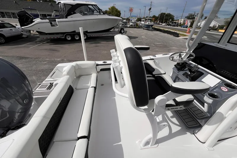 Slide: The Image of 2026 Tidewater 220 LXF boat interior with helm, seating, and controls in a dealership lot. - 15