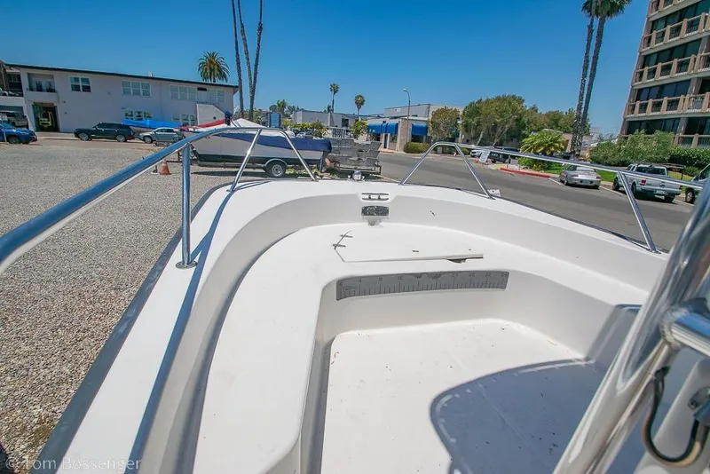 Slide: The Image of 2008 Boston Whaler 190 Montauk boat deck in a parking area with palm trees. - 10