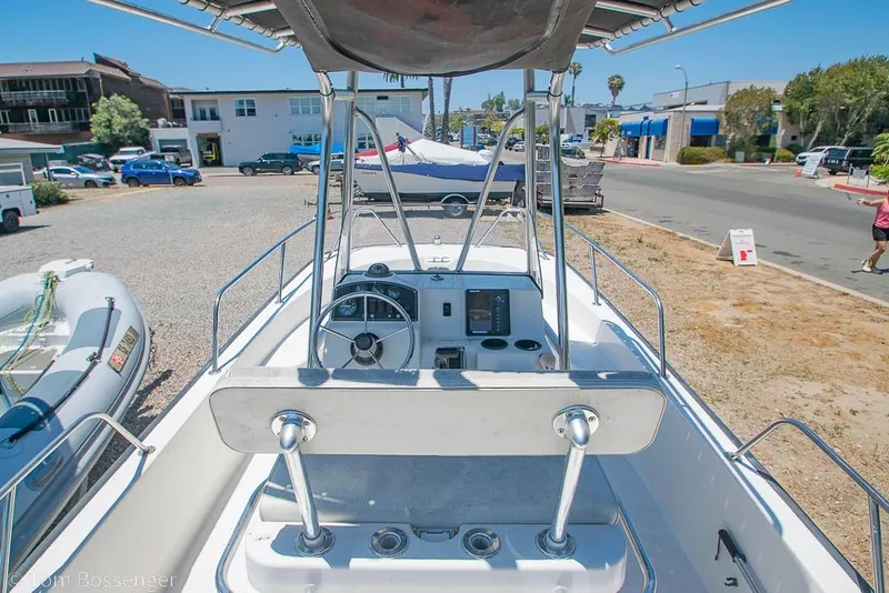 Slide: The Image of 2008 Boston Whaler 190 Montauk boat interior with steering console, parked outdoors. - 5