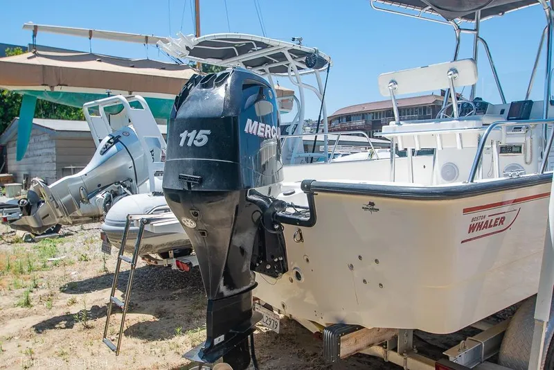 Slide: The Image of 2008 Boston Whaler 190 Montauk boat with Mercury 115 outboard motor in a yard. - 9