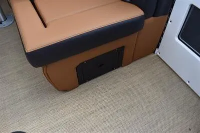 Slide: The Image of 2026 Princecraft Vouge 25 RL interior seating with tan upholstery and storage compartment. - 18