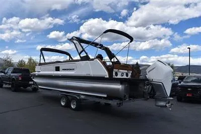 Slide: The Image of 2026 Princecraft Vogue 25 RL pontoon boat on trailer under cloudy sky. - 2
