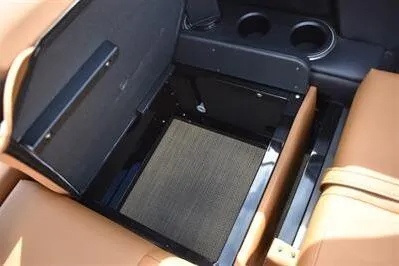 Slide: The Image of 2026 Princecraft Vouge 25 RL storage compartment with cup holders and tan seating. - 27