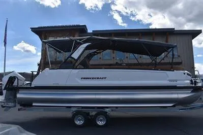 Slide: The Image of 2026 Princecraft Vogue 25 RL pontoon boat with canopy, parked on a trailer. - 48