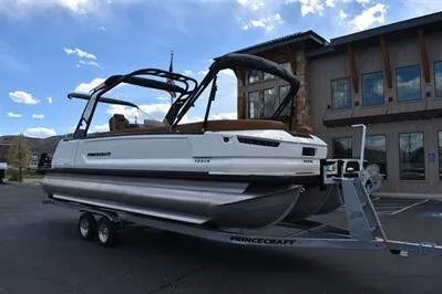 Slide: The Image of 2026 Princecraft Vogue 25 RL pontoon boat on trailer, parked outside a building. - 5