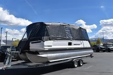 Slide: The Image of 2026 Princecraft Vogue 25 RL pontoon boat on trailer, covered, under a clear blue sky. - 53