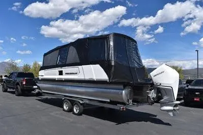 Slide: The Image of 2026 Princecraft Vogue 25 RL pontoon boat on trailer, parked outdoors under blue sky. - 55