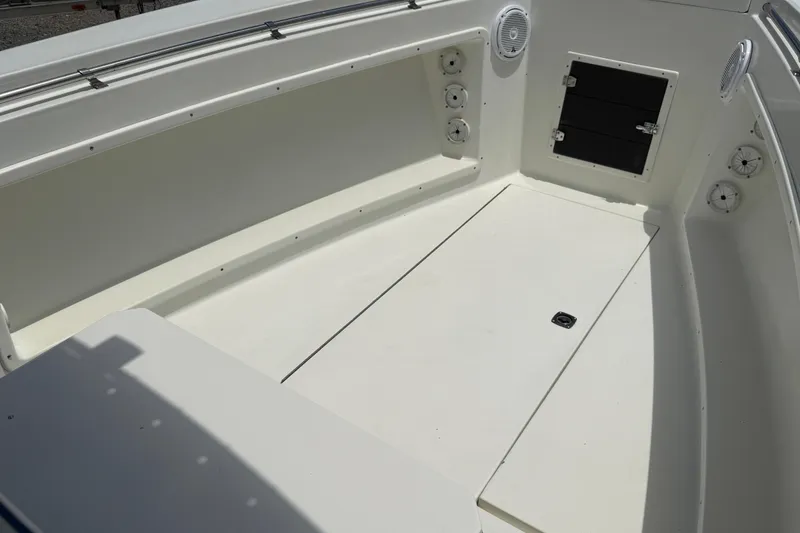 Slide: The Image of 1996 Contender 23 CC boat interior with white deck and storage compartments. - 12