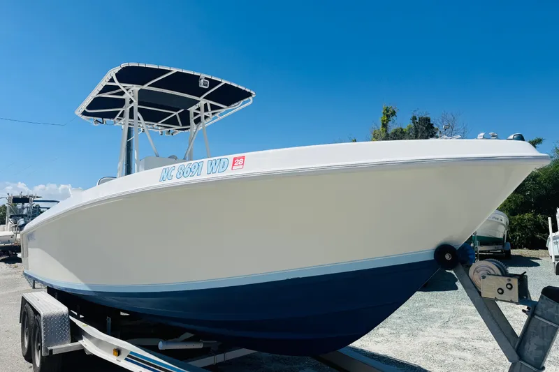 Slide: The Image of 1996 Contender 23 CC boat on trailer under clear blue sky. - 3