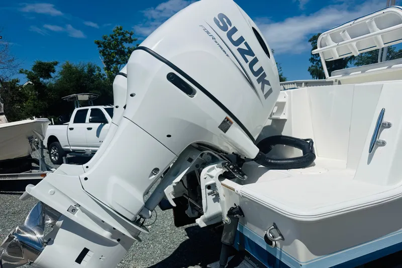 Slide: The Image of 1996 Contender 23 CC boat with Suzuki outboard motor, parked outdoors. - 5