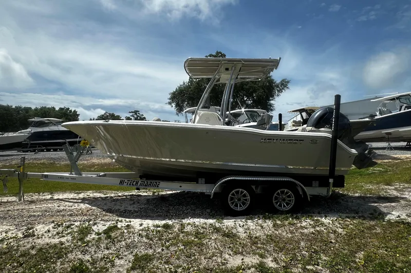 The Image of 2026 Key West 203 FS boat on trailer, parked outdoors under a cloudy sky. - 1