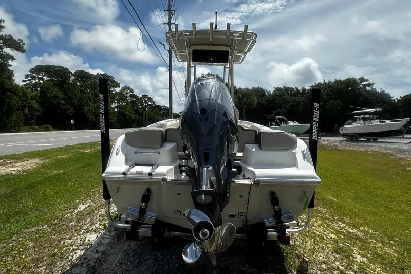 Slide: The Image of 2026 Key West 203 FS boat with powerful outboard motor, parked on grassy roadside. - 2