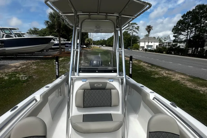 Slide: The Image of 2026 Key West 203 FS boat interior with seating and console, parked near a road. - 9