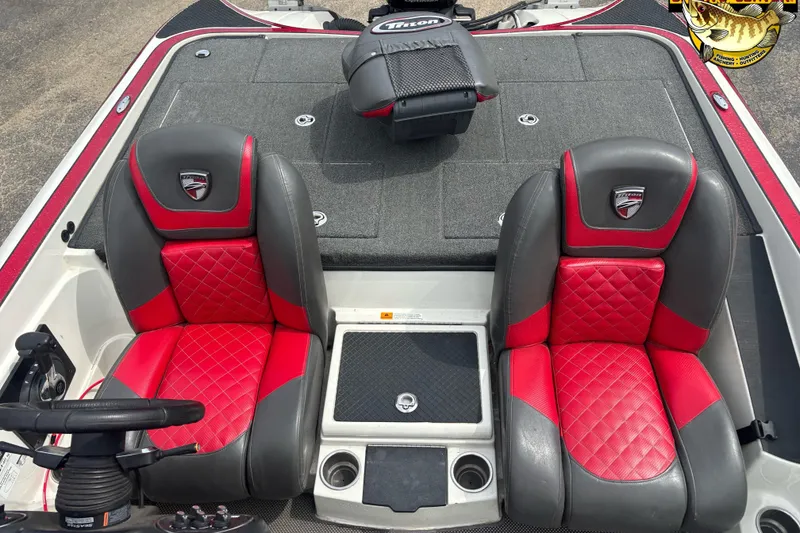 Slide: The Image of 2018 Triton 20 TrX boat interior with red and gray seats, steering wheel, and storage. - 6