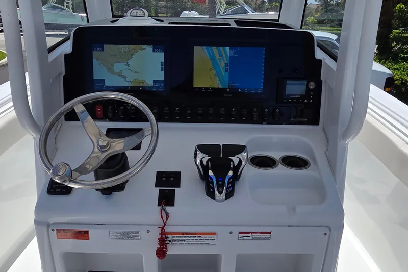 Slide: The Image of 2025 Sea Hunt Ultra 265 SE boat dashboard with navigation screens and steering wheel. - 18