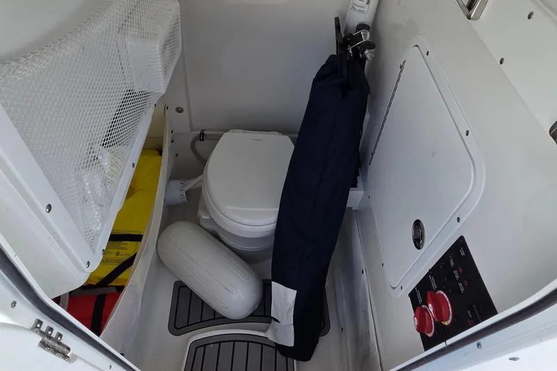 Slide: The Image of Interior of 2025 Sea Hunt Ultra 265 SE boat with toilet and storage area. - 19