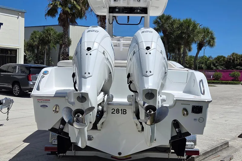 Slide: The Image of 2025 Sea Hunt Ultra 265 SE boat with dual outboard engines, parked outdoors. - 3