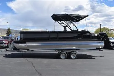 The Image of 2026 Princecraft Quorum 25 RL pontoon boat on trailer, parked outdoors. - 0
