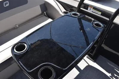Slide: The Image of 2026 Princecraft Quorum 25 RL boat interior with sleek table and cup holders. - 12